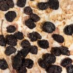 Oven dried cherries on a parchment paper lined baking sheet